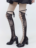 Black lace thigh-high stockings with floral designs on a white background