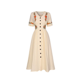 Beige dress with floral embroidery on a white background