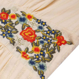 Embroidered floral design on a beige fabric background