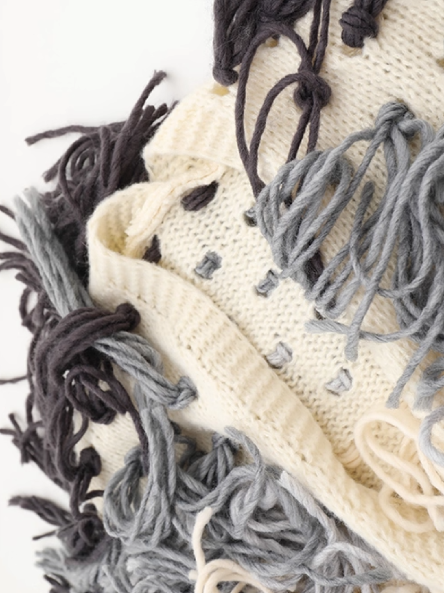 Close-up of textured fabric with black, gray, and beige yarn strands.