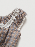 Plaid baby romper with ruffled lace details on a light background